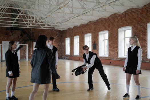 Teenagers in school uniforms interacting inside a brick-walled gymnasium, exploring social dynamics.