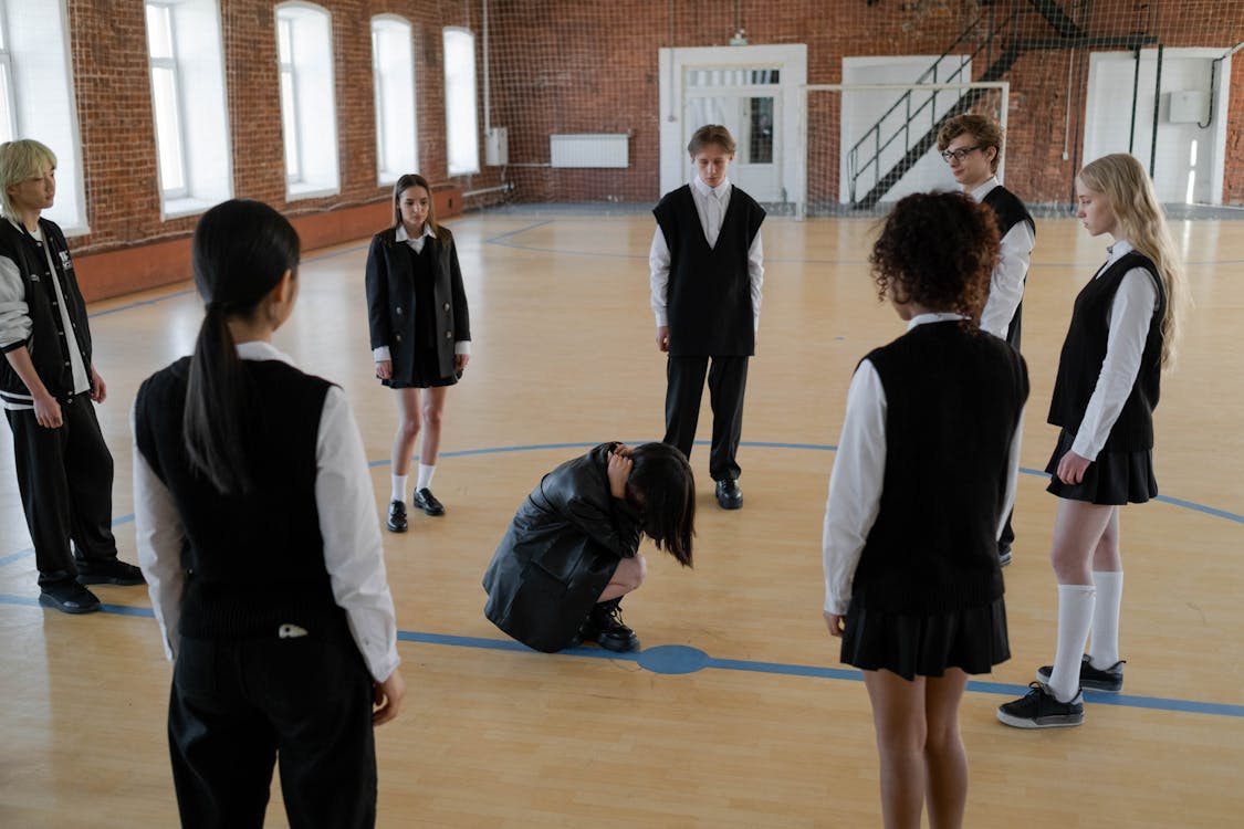Image of teenagers building their colleague in a circle