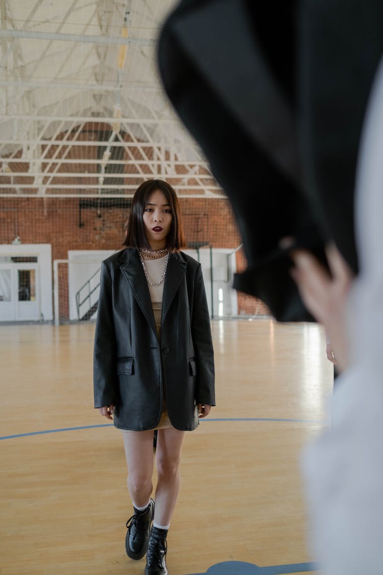 Young Girl In Black Coat Standing On The Floor