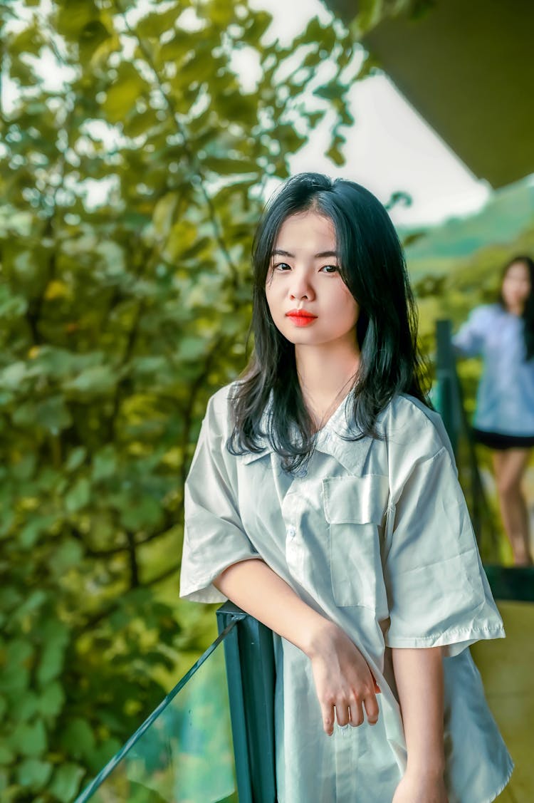 A Beautiful Girl Leaning On A Glass Balustrade