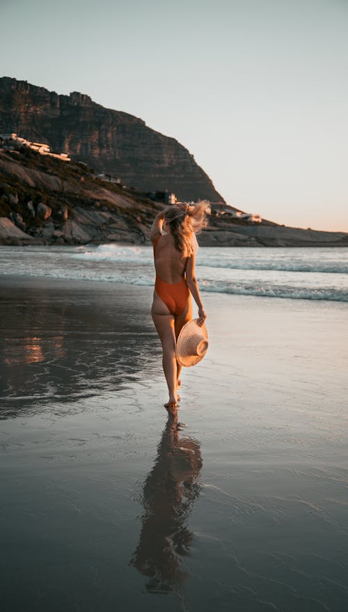 Woman in Orange Swim Suit Standing on Seashore