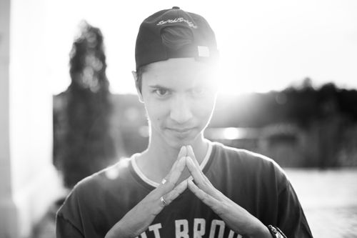 Free Black and white portrait of a man with hands together, backlit by sunlight outdoors. Stock Photo