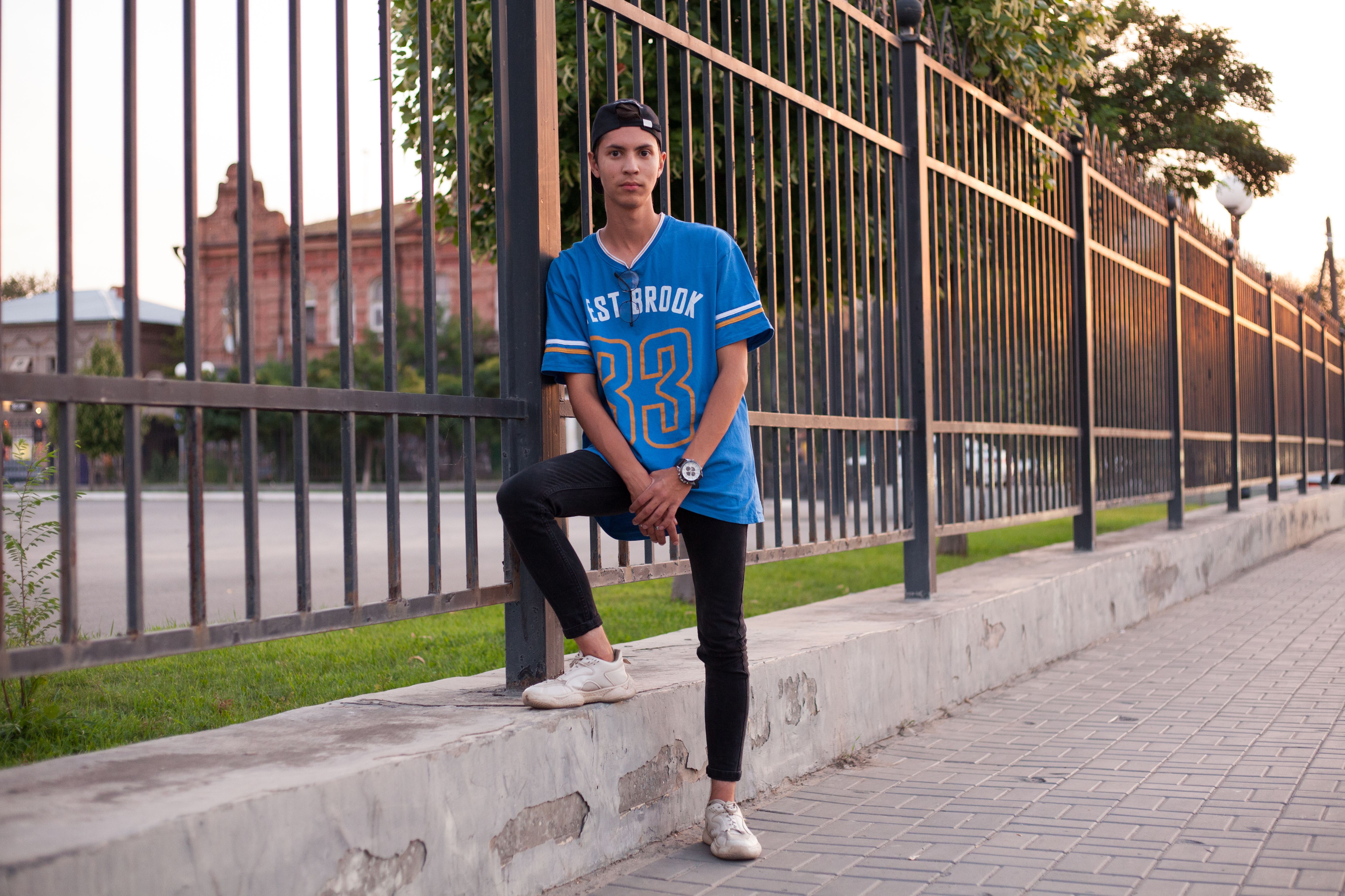Man Leaning on Metal Fence · Free Stock Photo