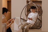 A Man and a Woman Using Their Smartphones while Sitting