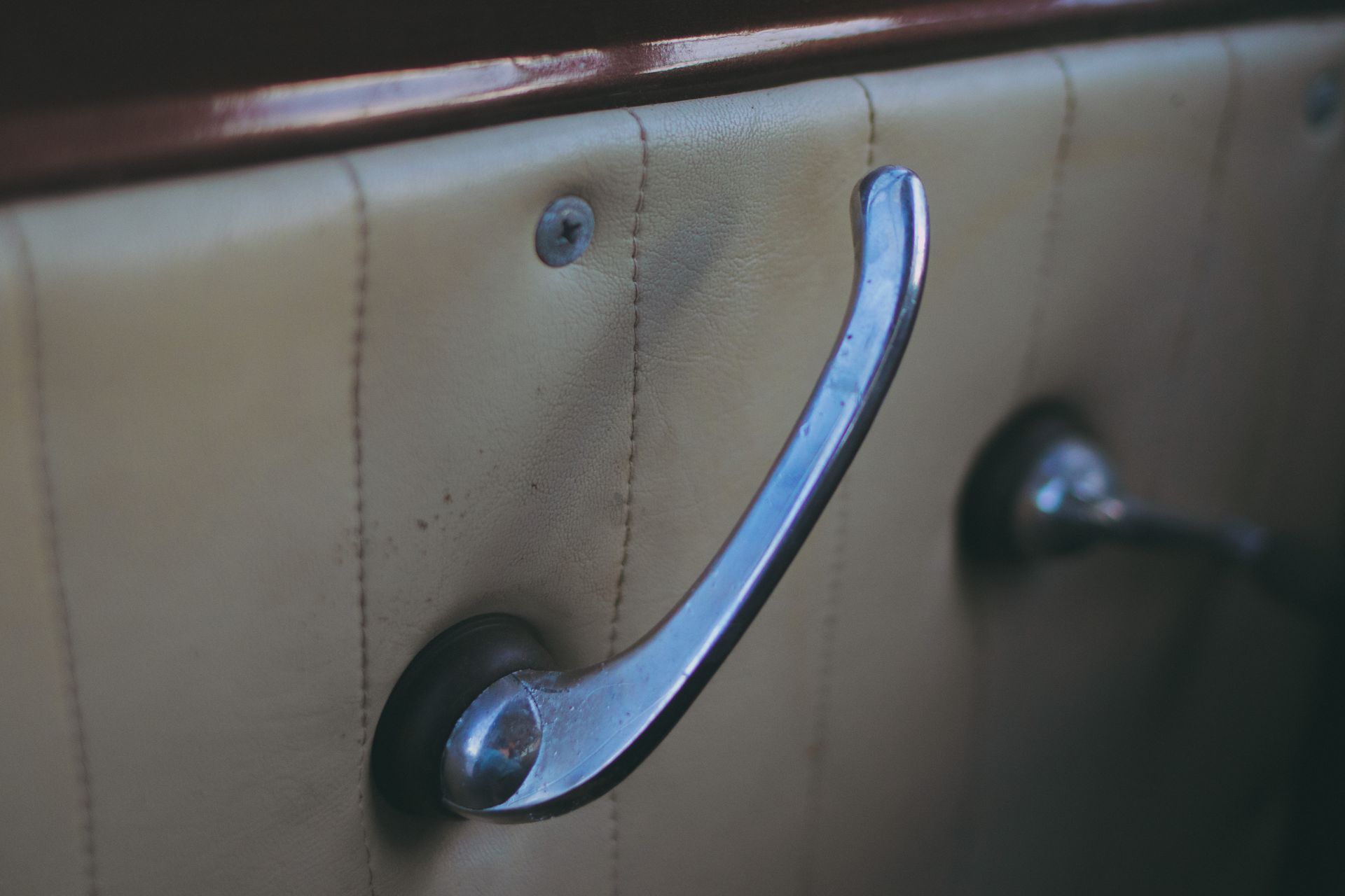 Close-up of a vintage car door handle showcasing retro design and patina.