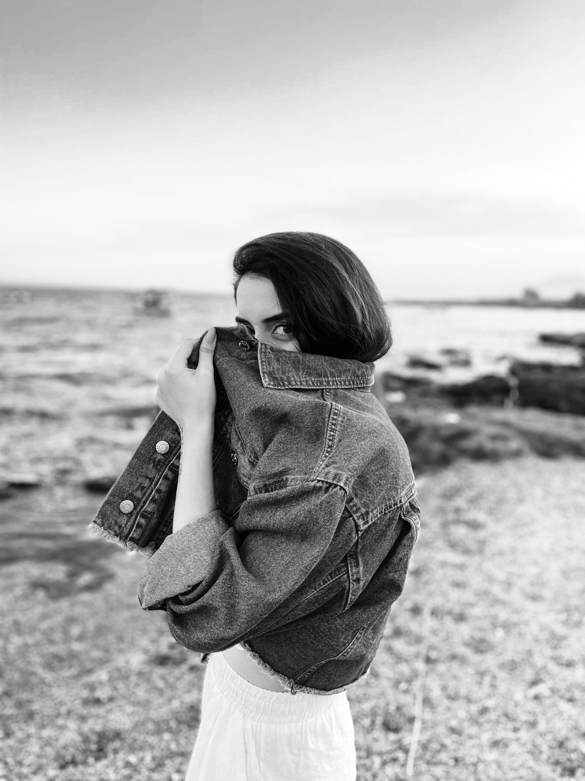 A grayscale shot of a woman with a denim jacket — denim as a designer fabric
