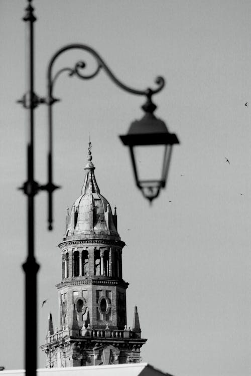 Grayscale Photo of Church's Bell Tower and Street Light