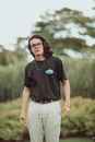 Stylish young frowning man standing among plants