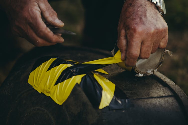 Person Holding Yellow And Black Tape