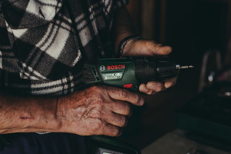 A Man Holding A Cordless Drill