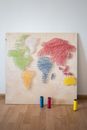 Creative world map created with colorful threads on canvas placed on wooden floor in light workshop