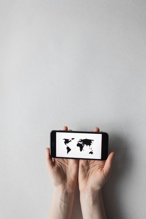 A Person Holding a Cellphone with a World Map on the Screen