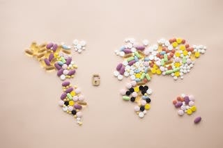 World map made of tablets and capsules and little lock