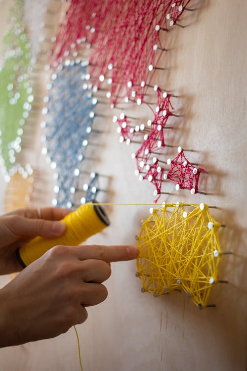 Crop artisan making string artwork