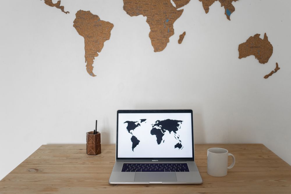 World map displayed on a laptop screen with silhouettes of continents