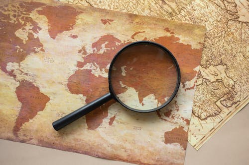 Close-Up Shot of a Magnifier and Maps