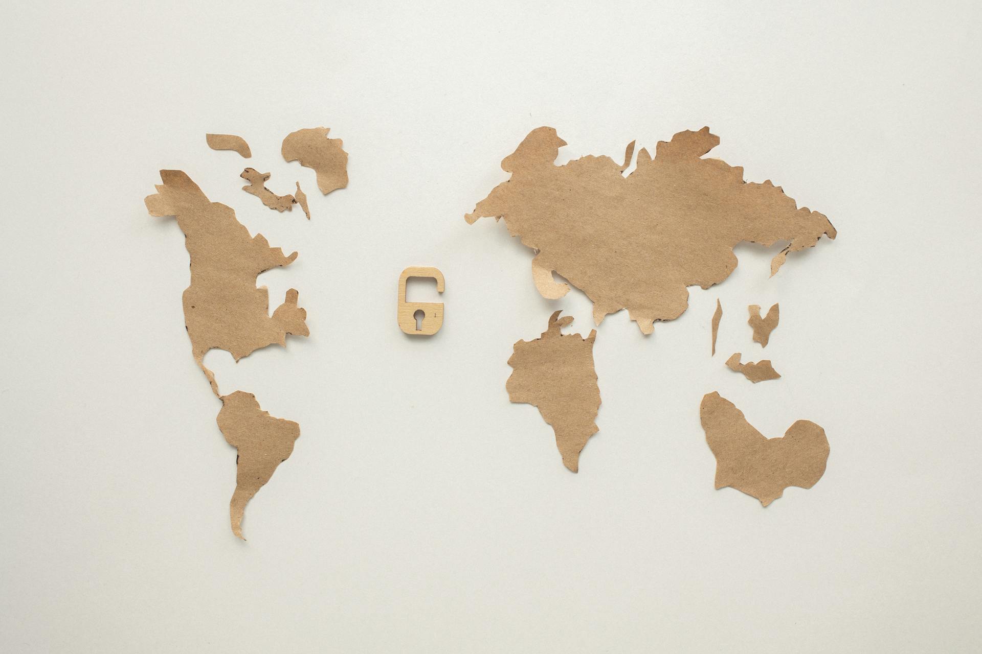 An artistic flat lay of a world map cutout accompanied by a padlock, symbolizing security.