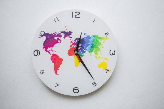 Round wall clock with colorful world map design and black hands, symbolizing global time.