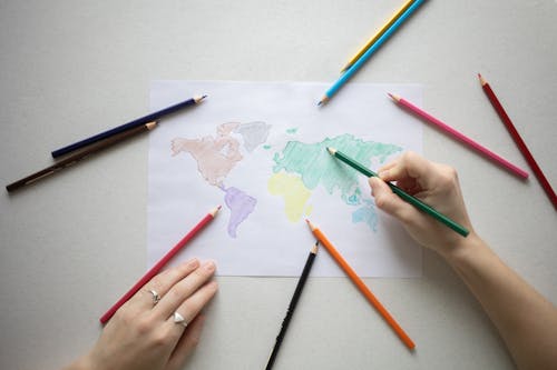 A Person Coloring a World Map Drawing