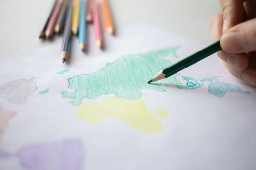 A Person Coloring a World Map Drawing