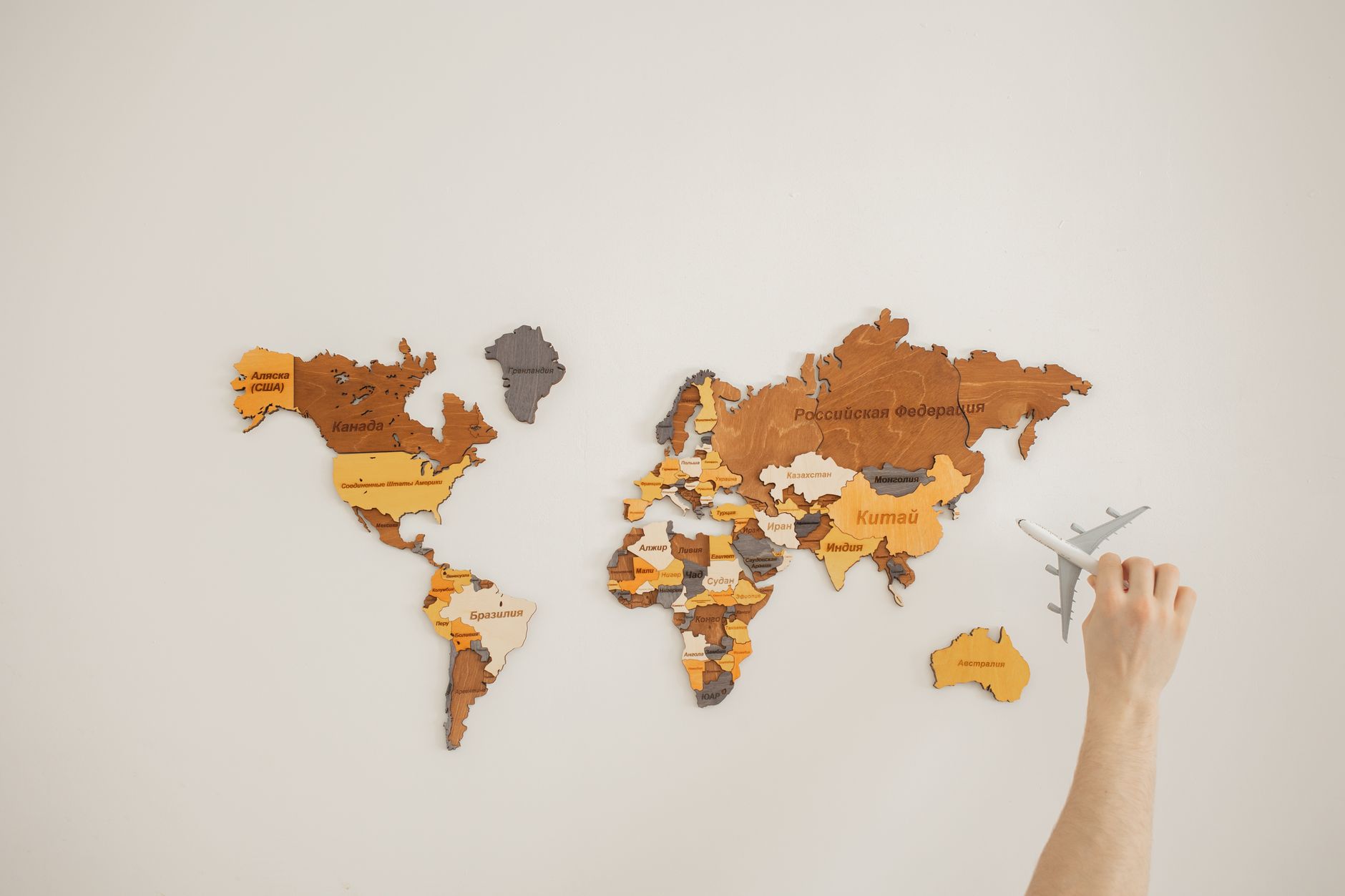 A person looking at a large world map on the wall with a thoughtful expression
