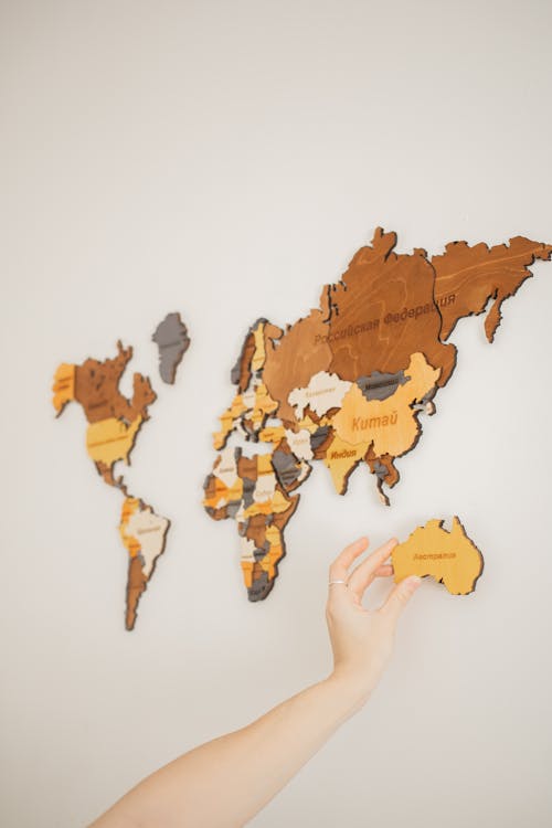 Faceless person attaching world map on wall