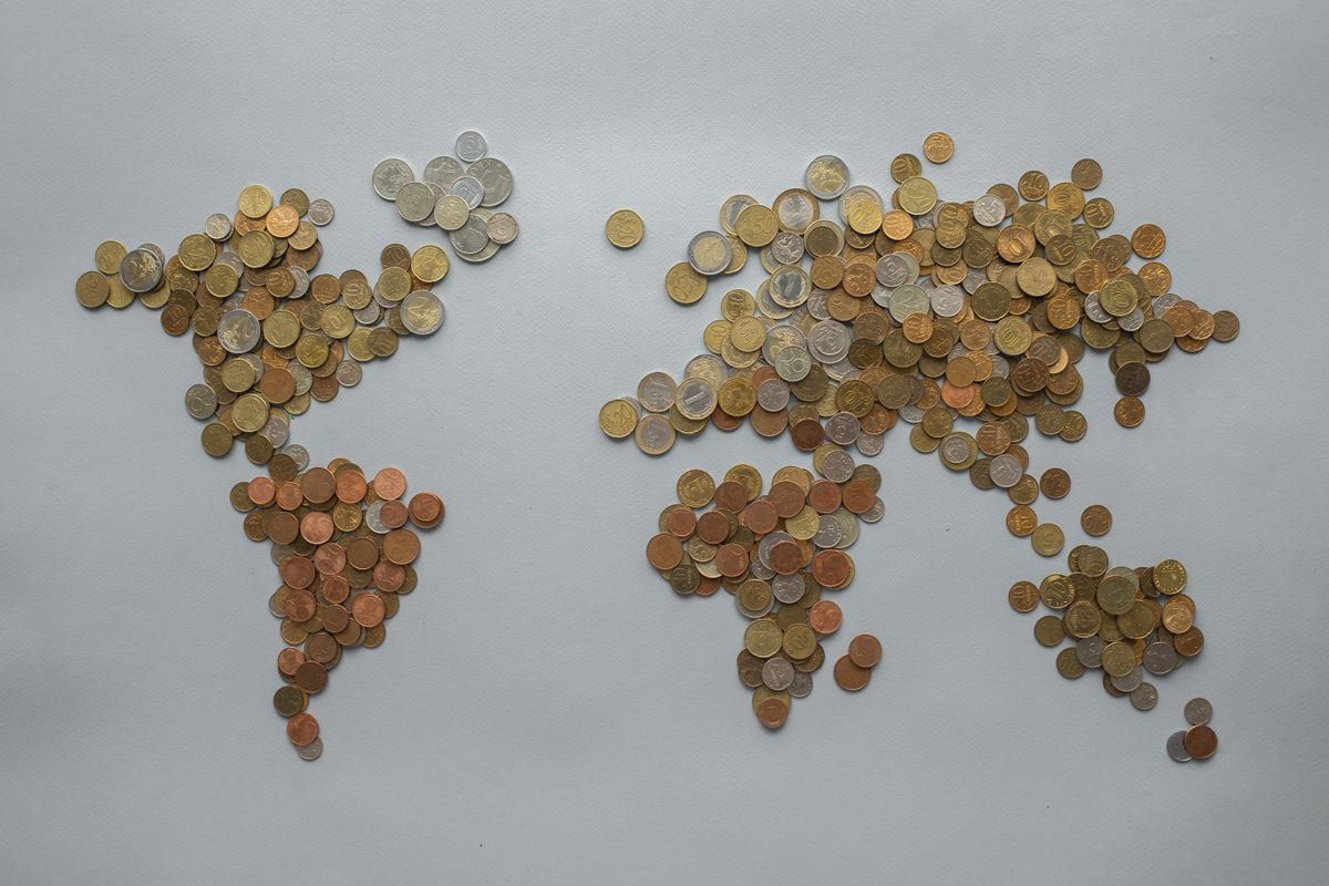 World map crafted from coins — global capital flow metaphor
