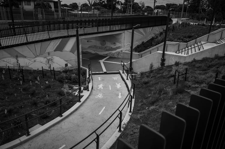 A Grayscale Of A Bridge And A Bike Path In A City