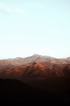 Captivating view of a mountain range at sunrise casting warm hues.