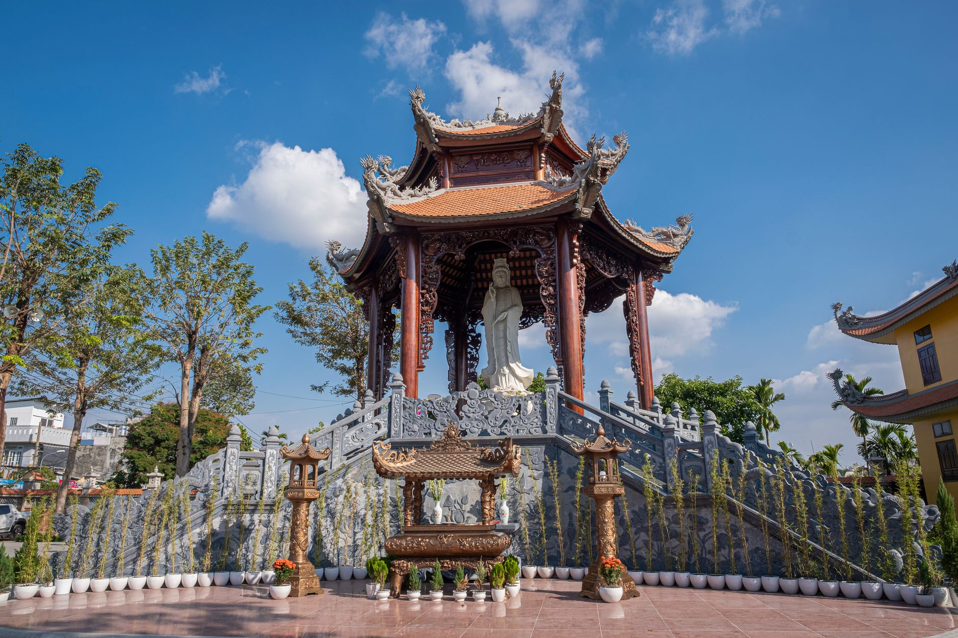 Traditional Buddhist shrine with intricate sculpture in Ho Chi Minh City, showcasing Vietnamese architecture under a blue sky.