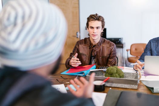 A group of young adults collaborating on a project in an office setting.