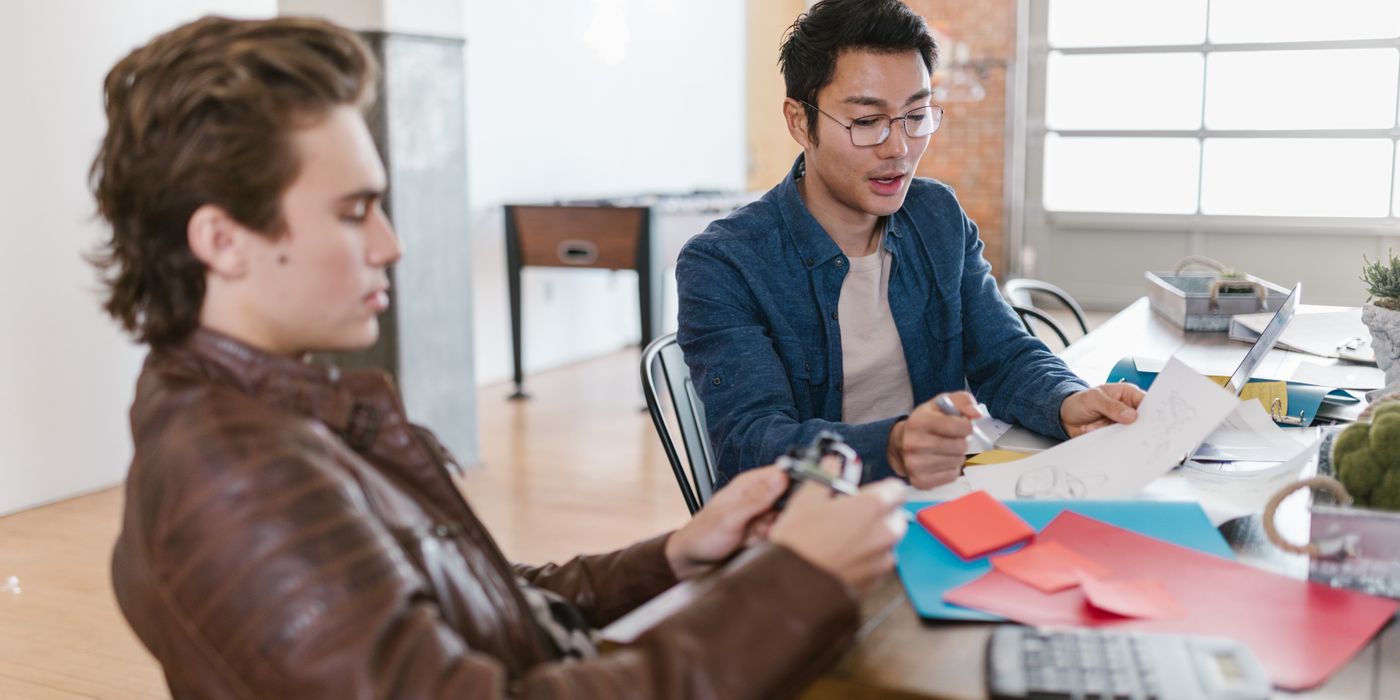 Two young entrepreneurs brainstorm ideas in a modern office setting, fostering innovation and collaboration.