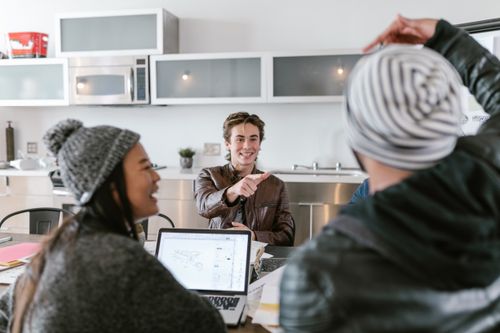 Free Young diverse team collaborating in a casual office environment, engaging in creative discussion. Stock Photo