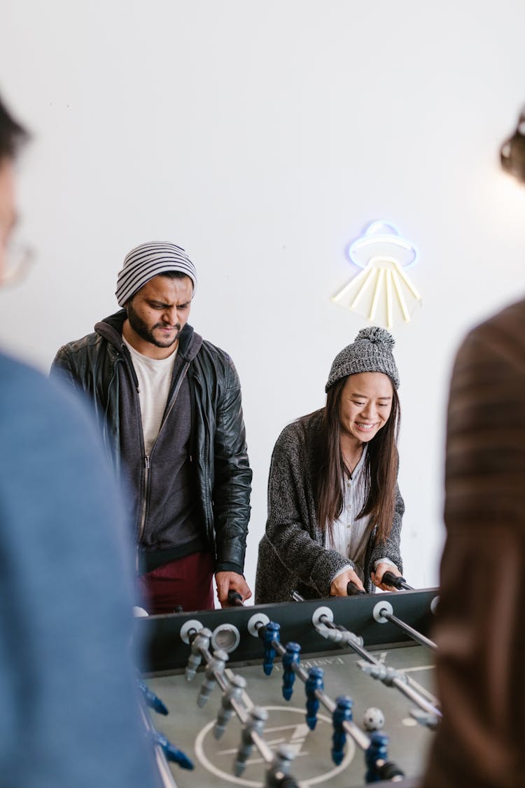 A Man And A Woman Playing A Table Game Of Soccer