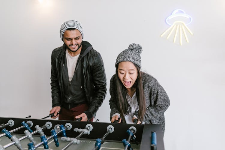 A Man And Woman Playing Foosball