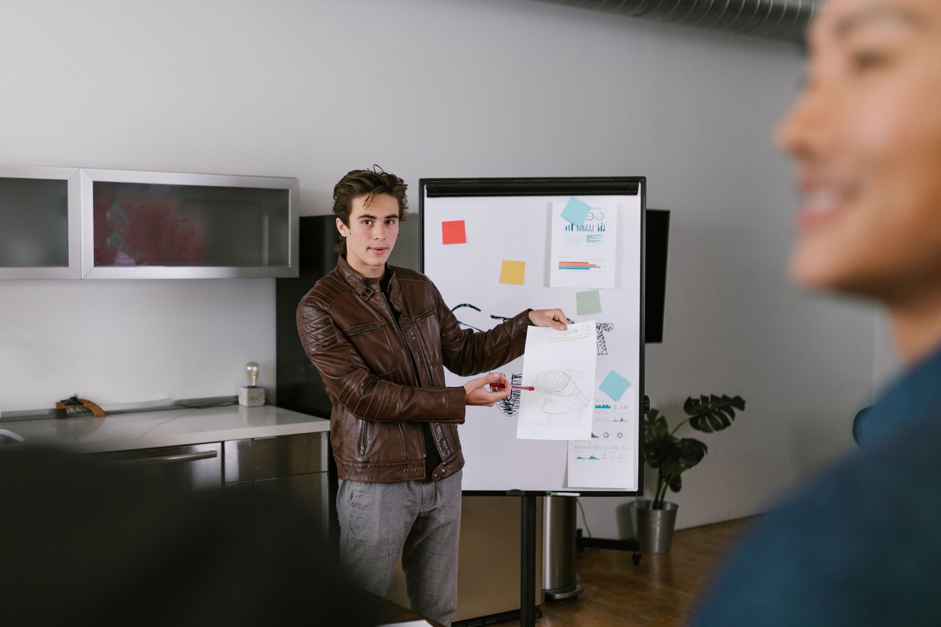 Man in Brown Leather Jacket Holding White Paper