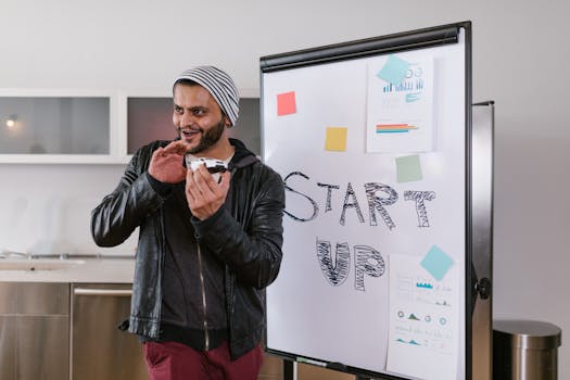 Man in leather jacket enthusiastically presents a startup idea on a flipchart indoors.