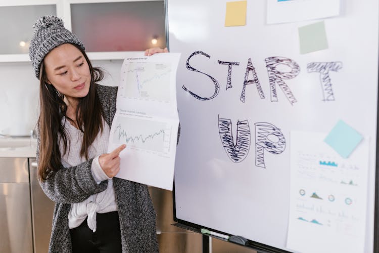 Woman Holding White Paper With Graphs