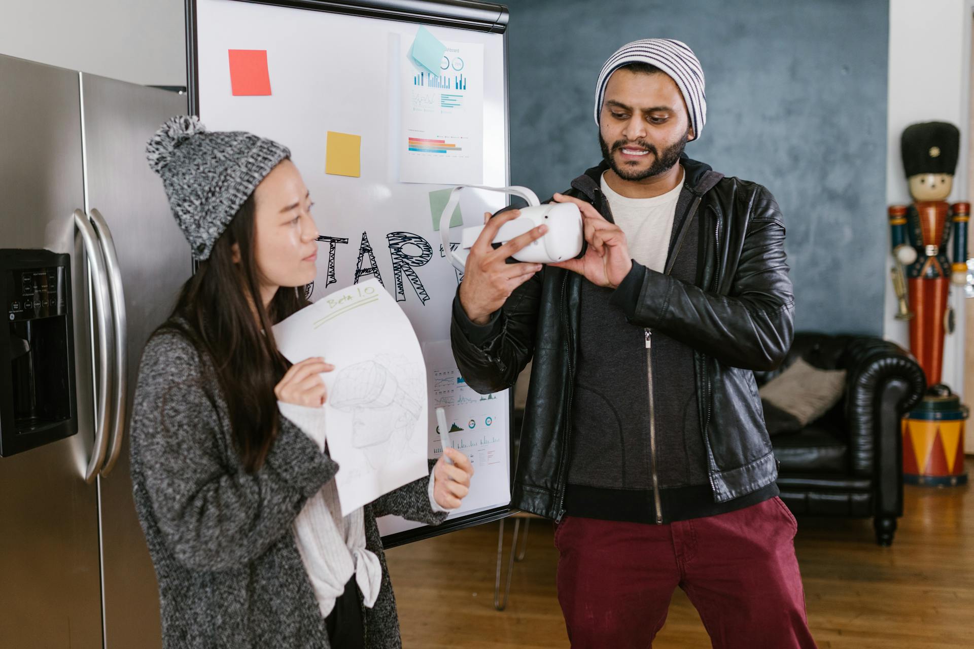 Two coworkers discussing a VR project in an office, focusing on a startup idea with whiteboard sketches.