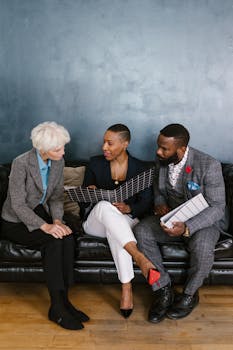 Three businesspeople having a meeting indoors, discussing documents together.