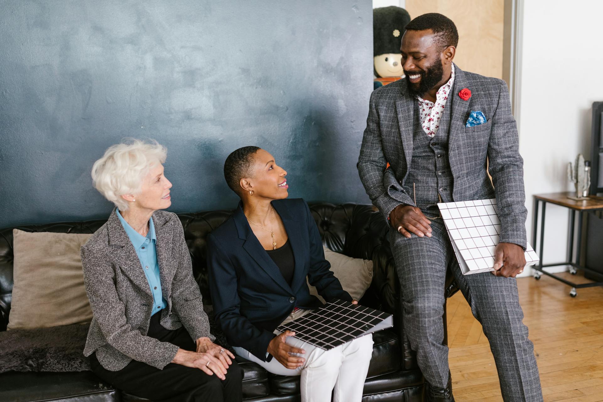 Three diverse business professionals engaging in a friendly meeting indoors.