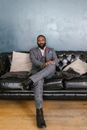 Man in Gray Suit Sitting on Black Leather Couch