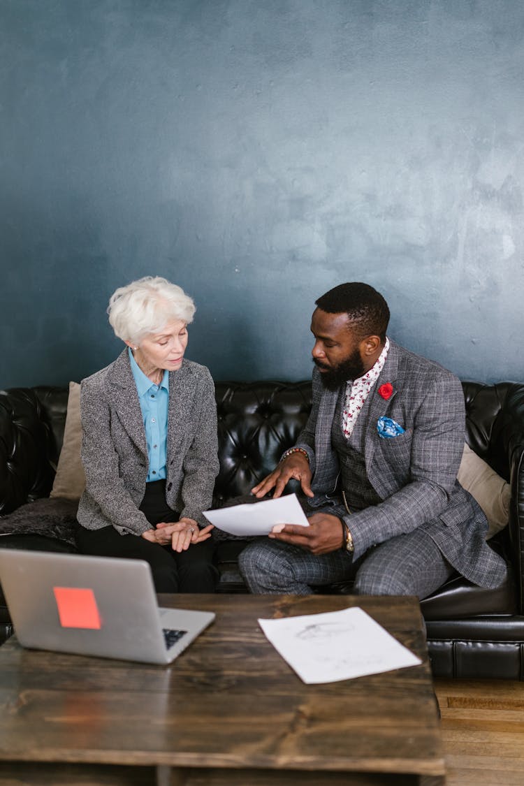 A Man And An Elderly Having A Discussion On A Couch