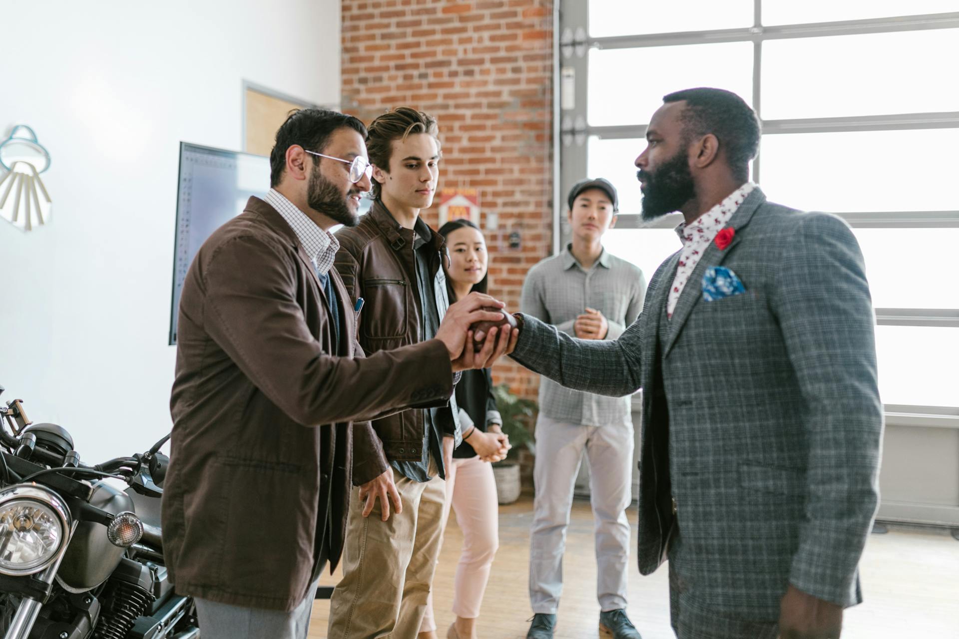 Group of diverse entrepreneurs exchanging greetings in a modern office space.