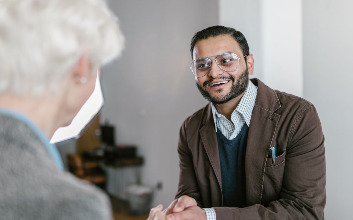 Two business professionals engaged in a friendly handshake indoors.