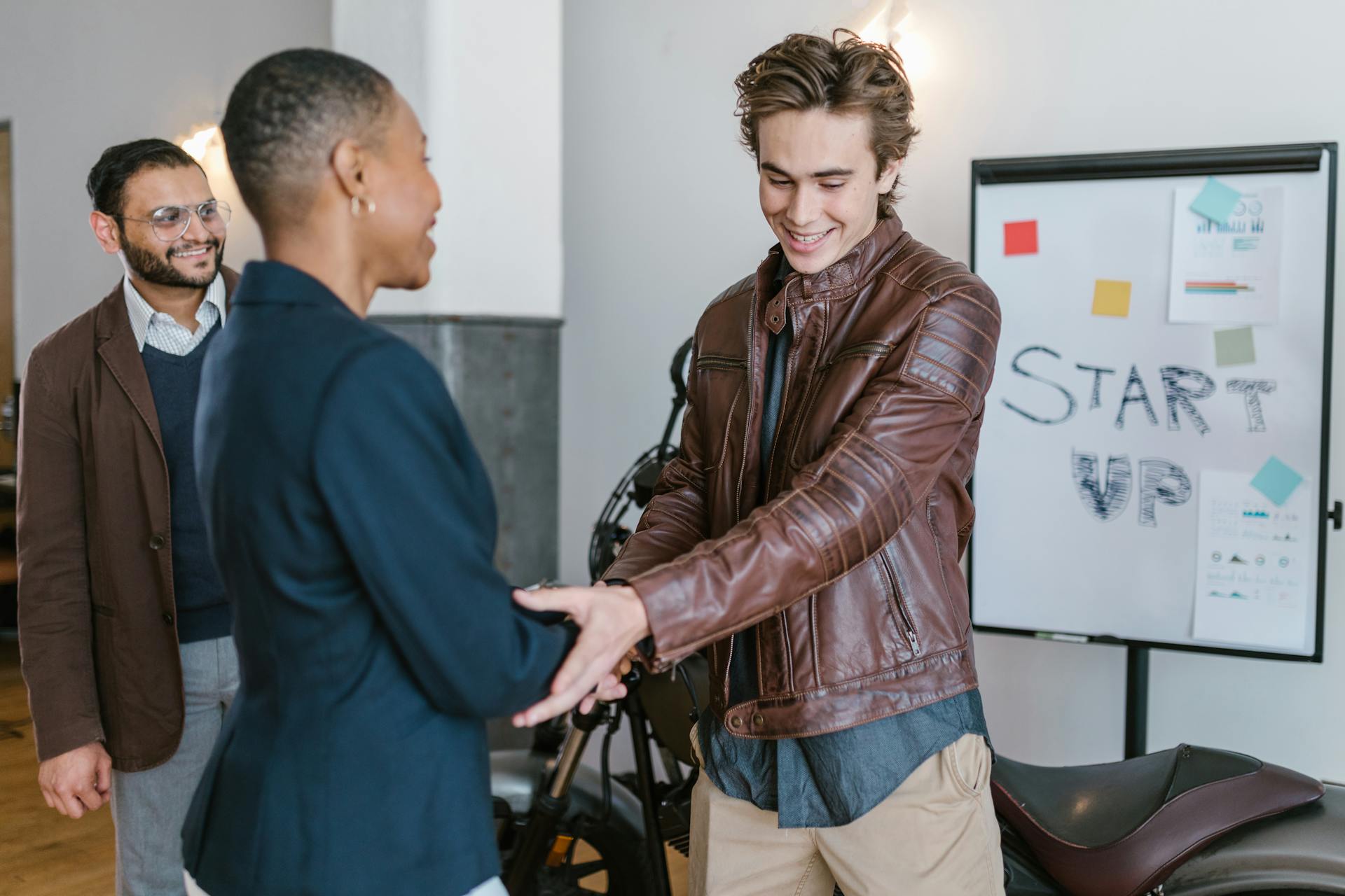 Professional young entrepreneurs shaking hands during a startup meeting indoors.