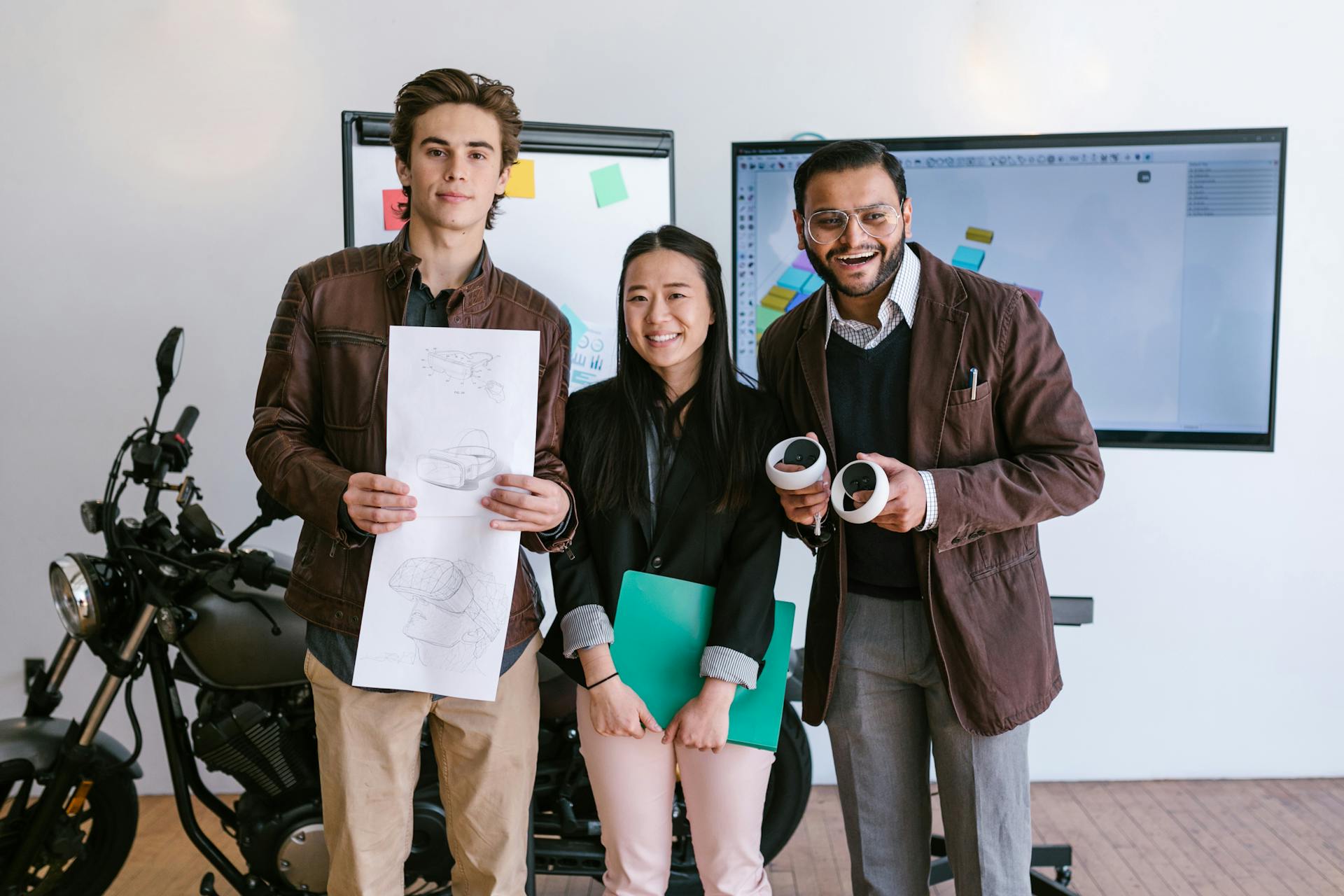 Diverse young entrepreneurs showcasing a new product prototype in a modern office.