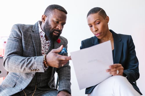 Free A Man and a Woman Looking at a Business Paper Stock Photo