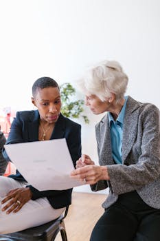 Two diverse professionals collaborating over a business document in an office setting.