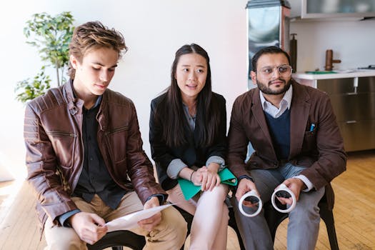 Three diverse employees discussing strategy in a bright office.